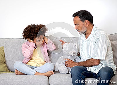 Strict Grandfather Scolding Naughty Grandson Boy For Misbehavior At Home Stock Photo