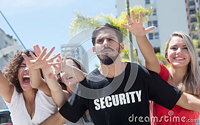 Strict security guard with groupies at concert Stock Photo