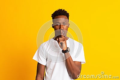 Strict young african guy says Shh, make silence please Stock Photo