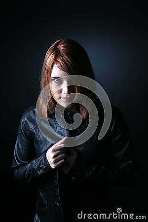 Striking red haired teen in black leather Stock Photo