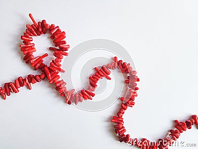 A string of beads from pieces of red coral on a white background Stock Photo