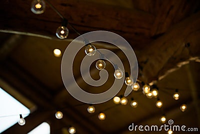 String of White and Yellow Lights Hanging in a Barn Stock Photo