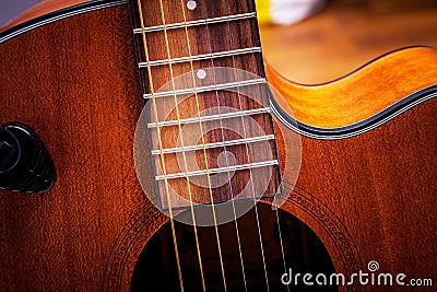 Strings on the fretboard of an acoustic guitar. Closeup Stock Photo