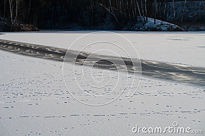 A strip of ice cleared of snow on the surface of a frozen pond, background Stock Photo