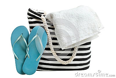 Striped beach bag with white bath towel and blue rubber slaps Stock Photo