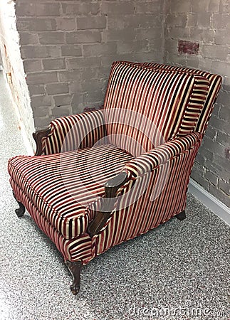 Striped Chair Against Brick Wall Stock Photo