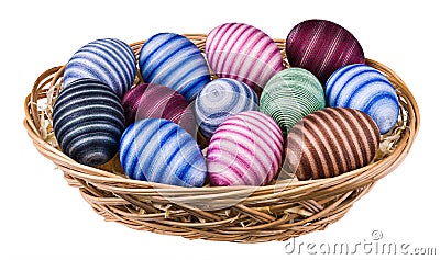 Striped hand-decorated Easter eggs in wicker basket isolated on white background Stock Photo