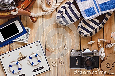 Striped slippers, camera, bag and maritime decorations on the wooden background Stock Photo