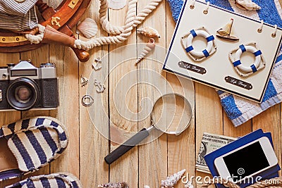 Striped slippers, camera, bag and maritime decorations on the wooden background Stock Photo