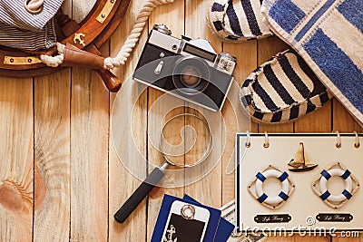 Striped slippers, camera, bag and maritime decorations on the wooden background Stock Photo