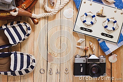 Striped slippers, camera and maritime decorations on the wooden background Stock Photo