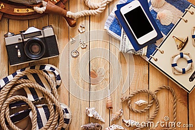 Striped slippers, camera, phone and maritime decorations, wooden background Stock Photo