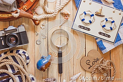 Striped slippers, towel, piggy bank, camera and maritime decorations, top view Stock Photo