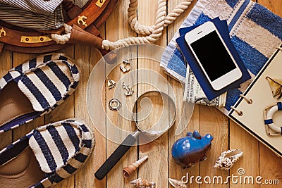 Striped slippers, towel, piggy bank, phone and maritime decorations Stock Photo