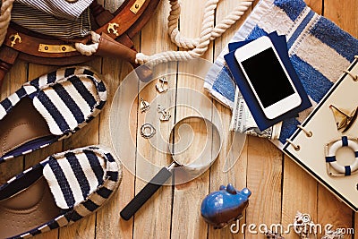 Striped slippers, towel, piggy bank, phone and maritime decorations, wooden background Stock Photo