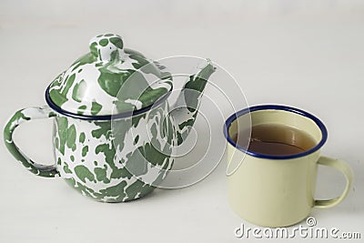Stripes vitreous enamel teapot and tea cups with tea Stock Photo