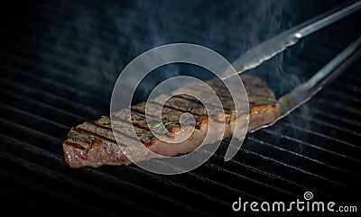 Striploin beef tip getting grilled on a barbeque grill. GRILLING Stock Photo