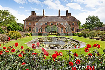 Strode House Barrington Court near Ilminster Somerset England uk with Lily pond garden and red dahlias in summer Editorial Stock Photo