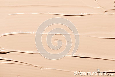 Strokes of beige foundation facial lotion with small contemporary makeup products as background extreme close upper view Stock Photo