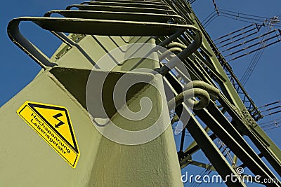 Electricity pylon with warning notice in German Stock Photo