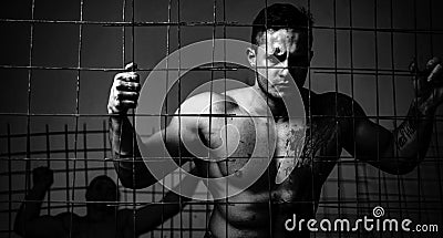 Strong aggressive monster behind grid. Prison for monster. Psycho mad man. Murderer mythical creature. Muscular man Stock Photo