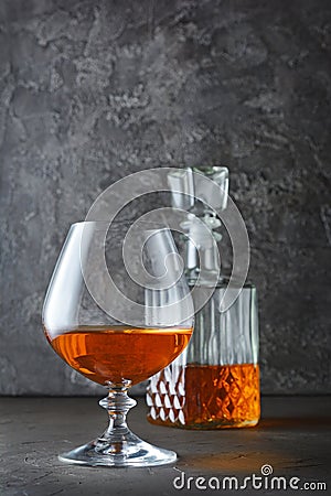 Strong alcoholic drink cognac in sniffer glass and crystal decanter Stock Photo