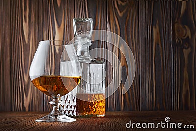 Strong alcoholic drink cognac in sniffer glass and crystal decanter Stock Photo