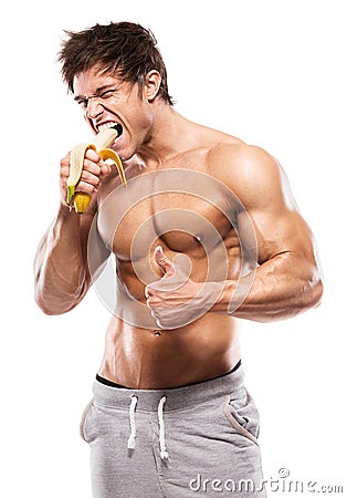 Strong Athletic Man showing muscular body and eating a banana Stock Photo