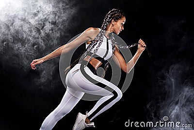 A strong athletic, woman sprinter, running on black background wearing in the sportswear, fitness and sport motivation Stock Photo