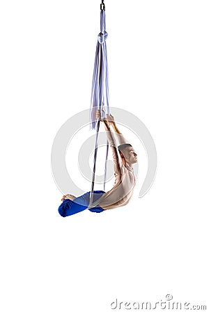 Strong, athletic young man, professional aerial gymnast, acrobat training with aerial tissues against white studio Stock Photo