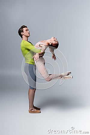 strong ballet dancer lifting ballerina in Stock Photo