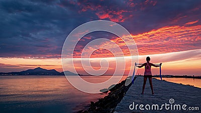 Strong confidence woman doing workout under the sunrise at seaside Stock Photo