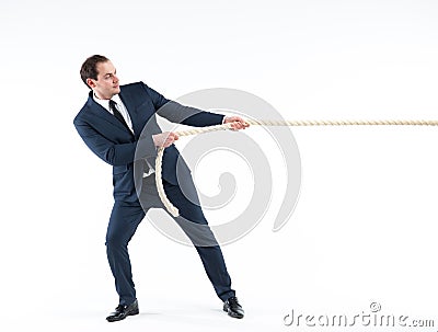 Strong and confident business leader. Side view of businessman in suit pulling a rope while standing against white Stock Photo