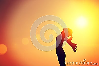 Strong confident woman open arms sunrise seaside Stock Photo