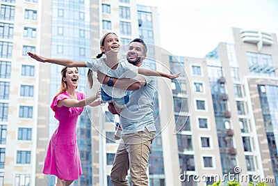 Delighted nice handsome man holding his daughter Stock Photo