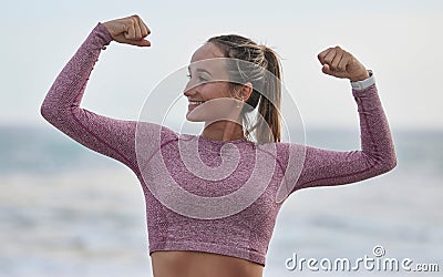 Strong, fitness and woman with muscle flex, exercise on beach and outdoor with nature, happy bodybuilder with power Stock Photo