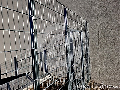 strong galvanized welded mesh fencing is used around industrial halls Stock Photo