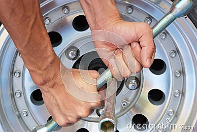 Strong hand try to remove the nut of wheel Stock Photo