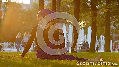 Strong islamic muslim indian woman in hijab active girl doing yoga in park outdoors training exercises tensing muscles Stock Photo