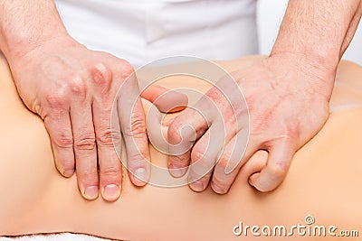 Strong male masseur`s hands knead the skin and muscles Stock Photo