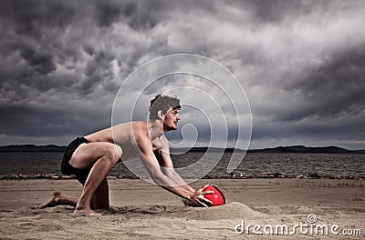 Strong male with red ball on the beach Stock Photo