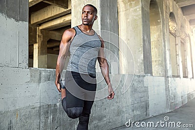 Strong male athlete in sportswear stretching legs, preparing for city jog, urban fitness and exercise Stock Photo