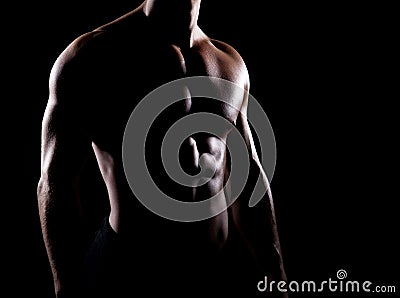 Strong and muscular body of man shaded over black background Stock Photo