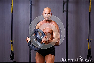 Strong ripped bald man pumping iron. Sports man bodybuilder posi Stock Photo