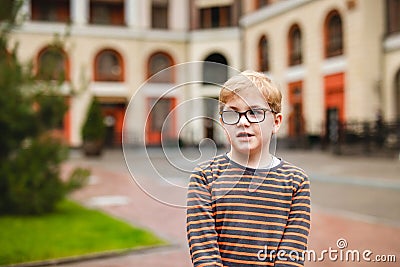 Strong, smart and funny little boy playing outdoors, wearing eyeglasses Stock Photo