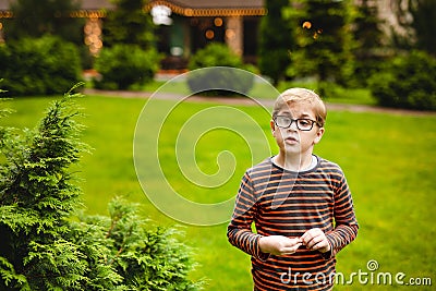 Strong, smart and funny little boy playing outdoors, wearing eyeglasses Stock Photo