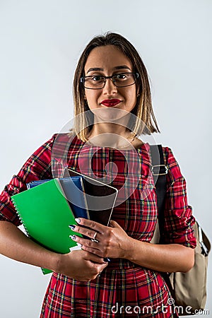Strong smart girl holding books in one hand in glasses on beautiful background. Stock Photo