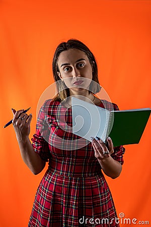 Strong smart girl holding books in one hand in glasses isolated on beautiful background. Stock Photo