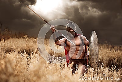 Strong Spartan warrior in battle dress with a shield and a spear Stock Photo