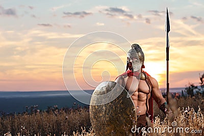 Strong Spartan warrior in battle dress with a shield and a spear Stock Photo